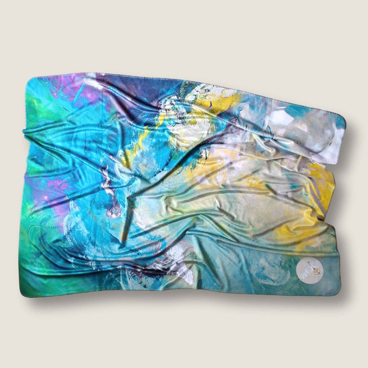 FORREST GUMP mit abstraktem Kunstmotiv in Türkis, Aqua, Blau, Grün, Pink und Gold. Farbenfrohe Kuscheldecke Kunst nach dem Originalgemälde von MYSTIQUE, locker drapiert vor hellem Hintergrund - INTO THE WOO.