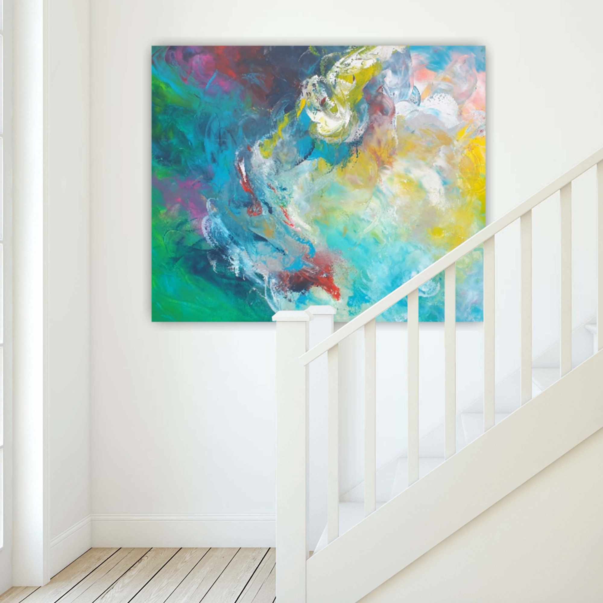 Abstraktes Gemälde in lebendigen Farben an einer weißen Wand neben einer Treppe mit Holzstufen und weißen Streben.
