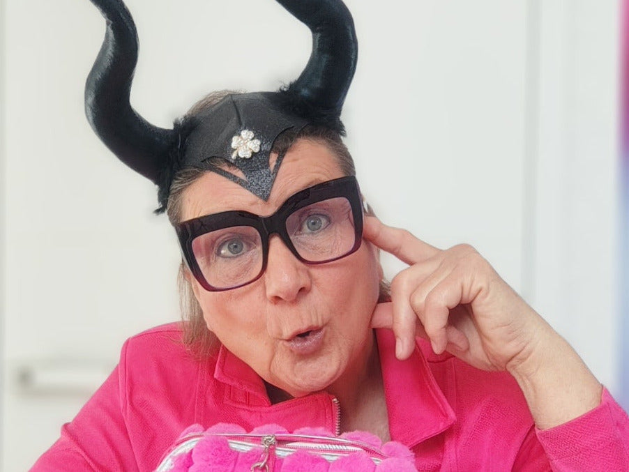 MYSTIC MAVERESS - mit pinkfarbener Jacke, Herrscherinnen-Hörnern und einer großen Brille
