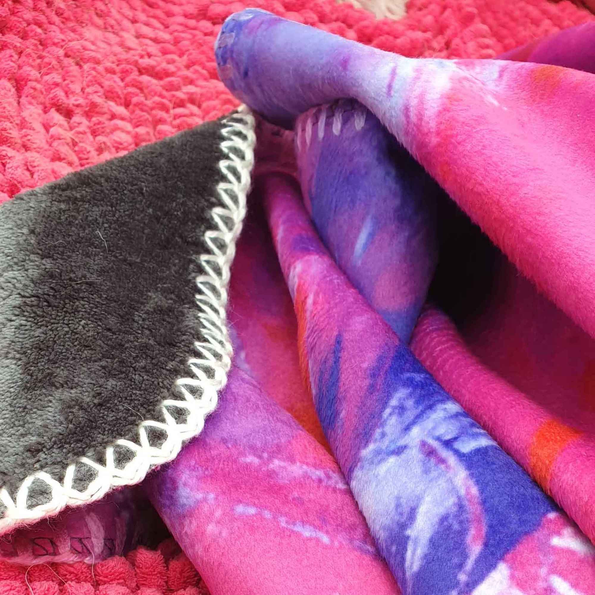 Kuscheldecke LA MER in Rosa, Pink und Lila auf rotem Untergrund
