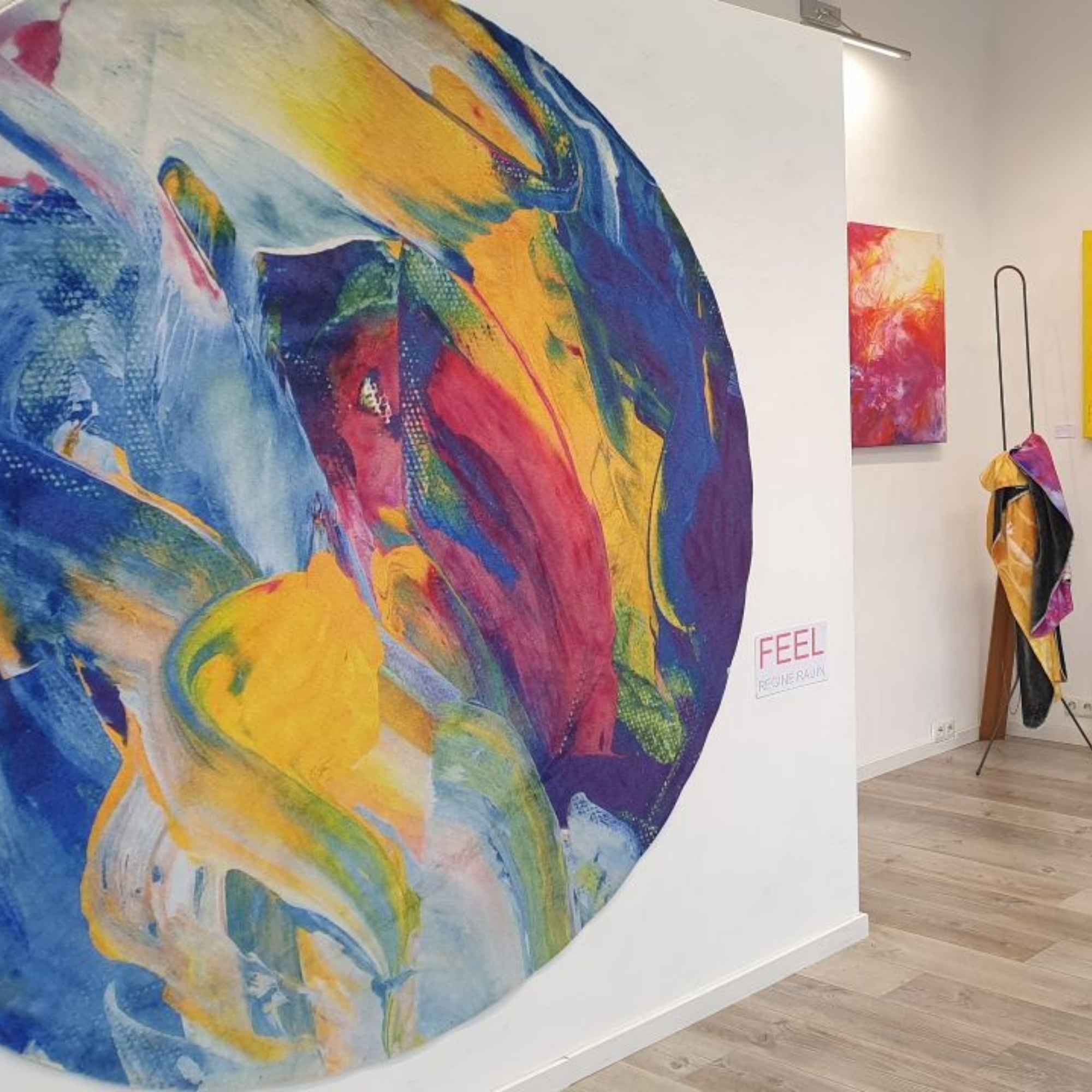 „Runder, farbintensiver Wandteppich mit abstrakter Malerei in Galerieausstellung.“
