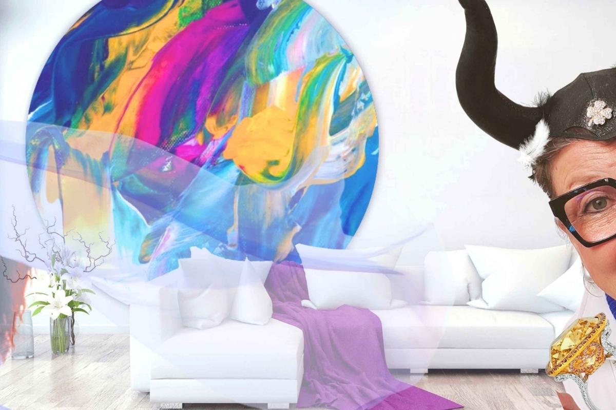 Blog_Kreative Kooperationen, Frau mit Hörnern schaut ins Bild, im Hintergrund ein farbenfroher runder Wandteppich hinter einem weißen Sofa mit violetter Decke, ein Schleier weht durchs Bild