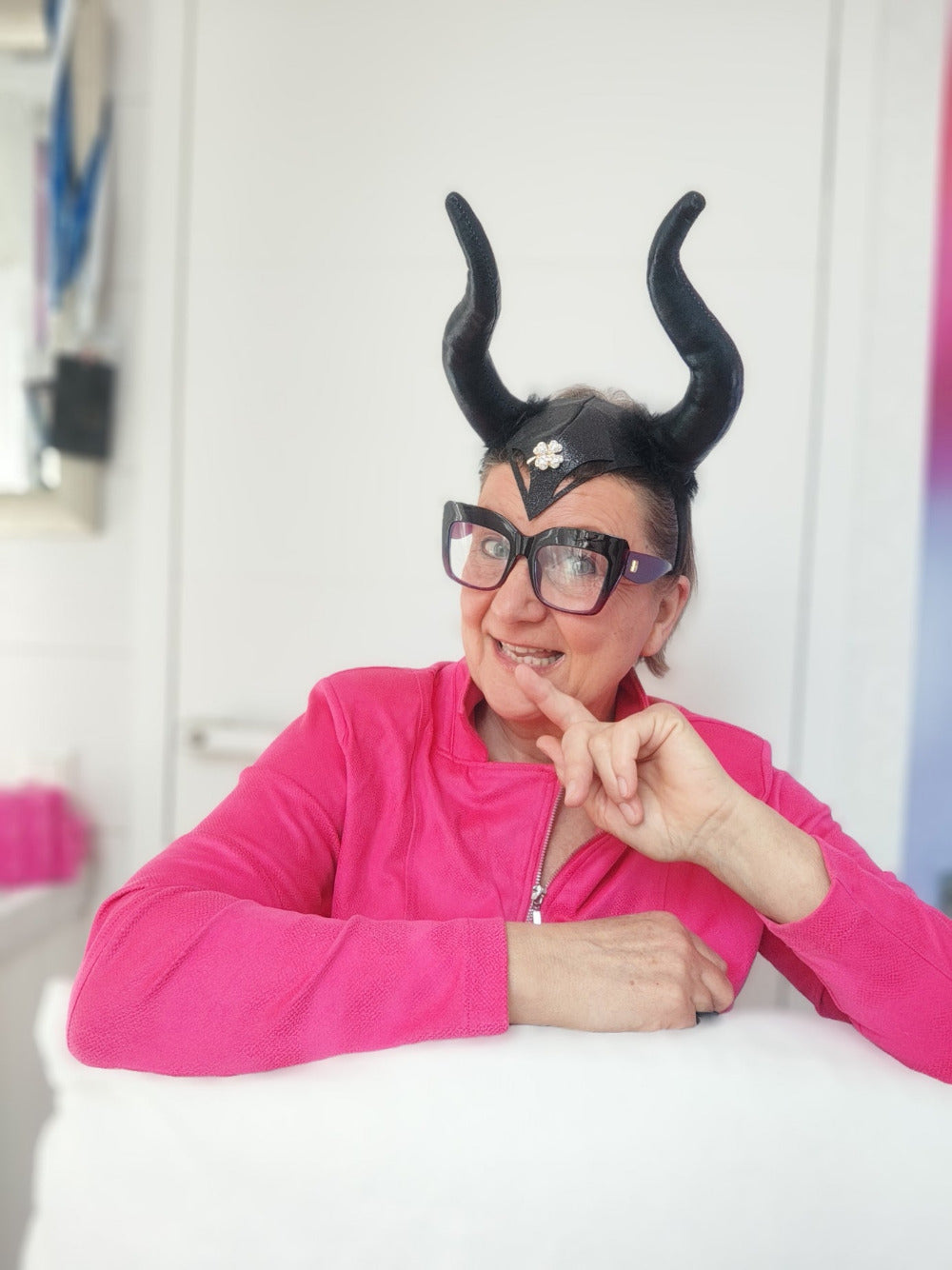 Pfiffige Mystic Maveress mit Designer-Brille, Herscherinnen-Hörnern auf dem Kopf und pinkfarbenem Oberteil
