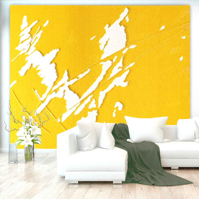 „Gelb-weißer, abstrakter Wandteppich hinter weißem Sofa mit grüner Decke.“ HEALING SCARS, Künstlerin: Regine Rauin