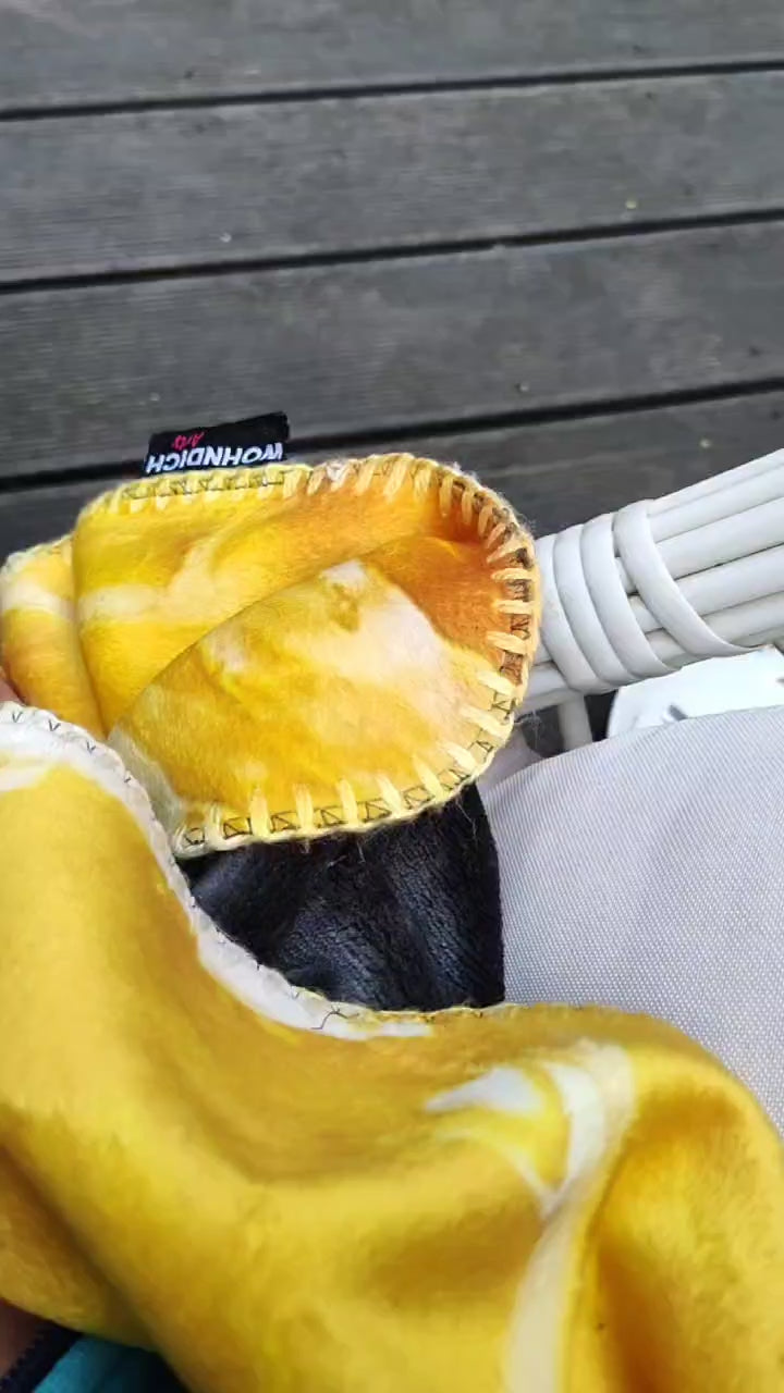 Ausschnitt weißer Hängesessel schaukelt, links sieht man eine goldgelbe Kuscheldecke von wohndich.arts, mit luftiger Musikuntermalung